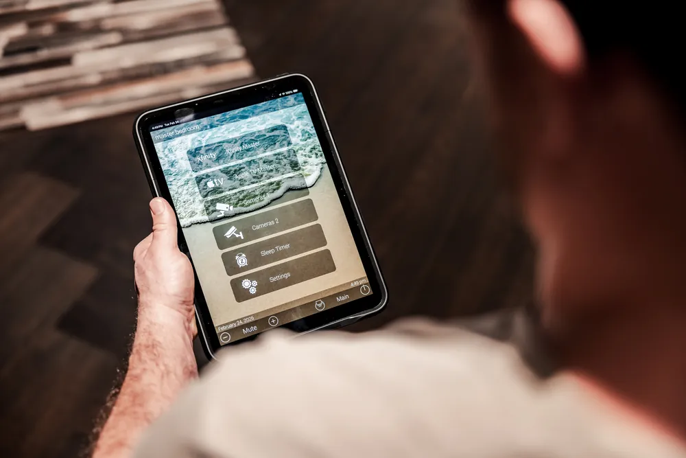 Tablet showing a custom home control interface with named sources and cameras